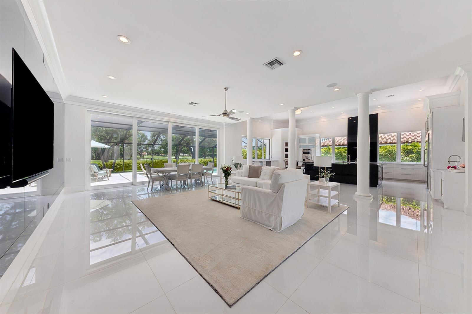 A white, single-story house with a central arched entryway, columns, and palm trees at dusk — 11938 N Lake Drive, Boynton Beach FL 33436, BOYNTON BEACH, FL