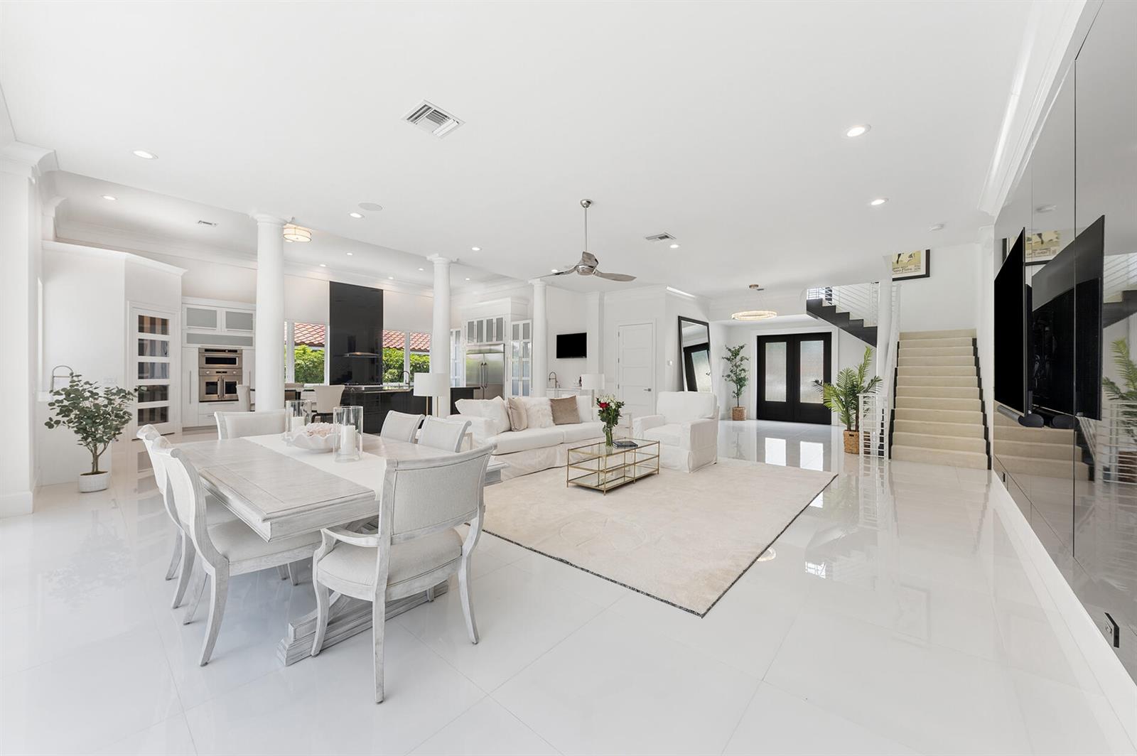 A modern living room features a large black wall, white furniture, and sliding glass doors — 11938 N Lake Drive, Boynton Beach FL 33436, BOYNTON BEACH, FL