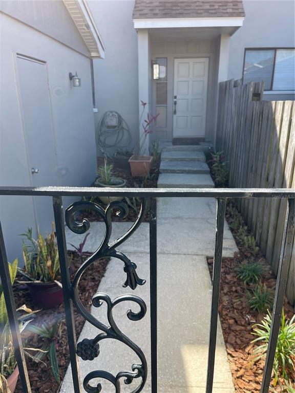 A concrete walkway leads to a front door with steps, framed by a metal railing — 3307 KILMER DRIVE UNIT 3307, LAKELAND, FL