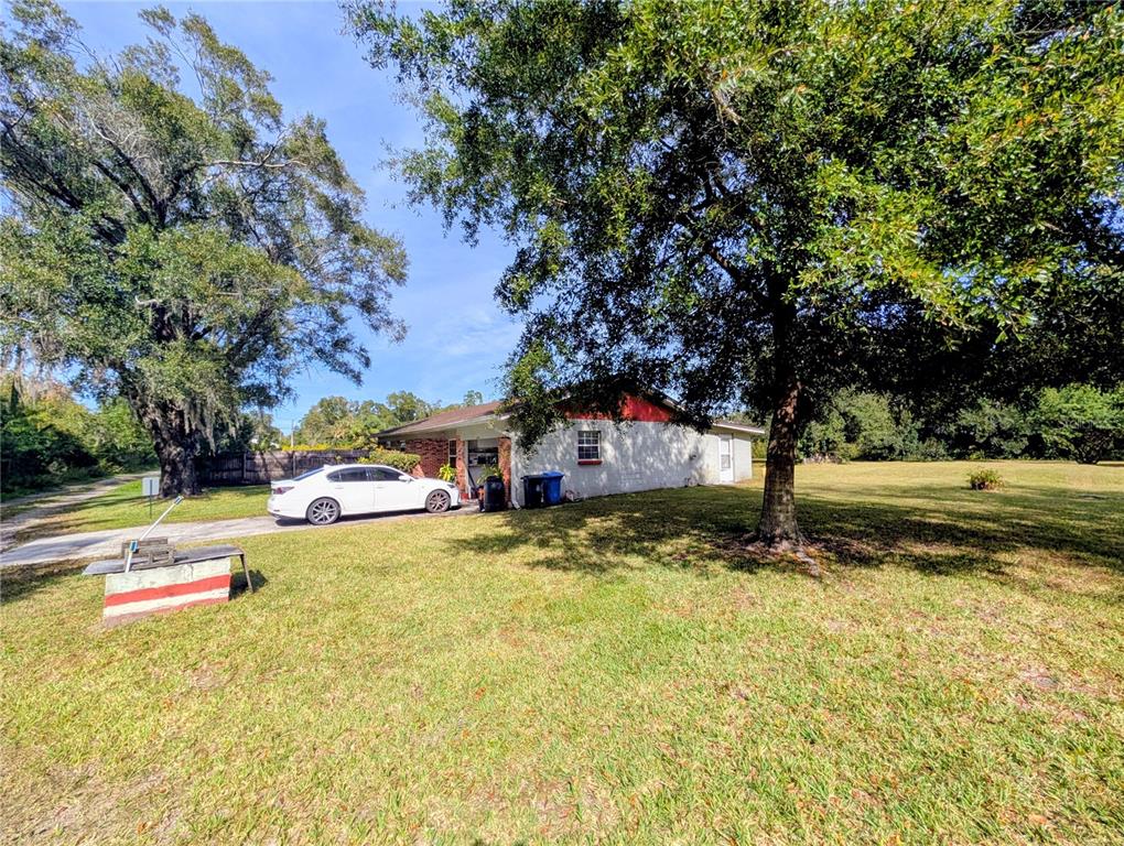 A white sedan is parked on a concrete driveway beside a single-story house — 8410 PETERSON ROAD, ODESSA, FL