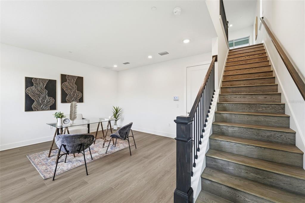 A home office area with a glass desk and stairs leading to an upper floor — 9156 SINATRA LANE, ORLANDO, FL