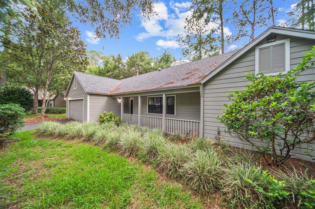 A single-story house with gray horizontal siding, a covered front porch, and a two-car garage — 8025 SW 47TH COURT, GAINESVILLE, FL