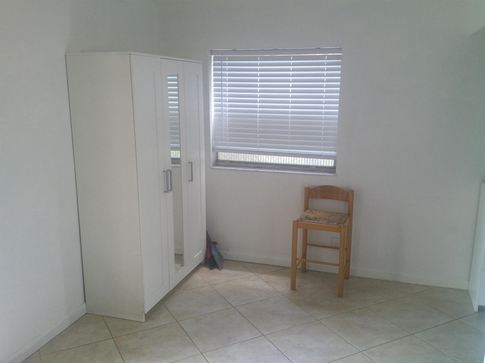 A room with white walls, tile flooring, a white wardrobe, and a wooden chair — 588 Brittany M, Delray Beach FL 33446, DELRAY BEACH, FL