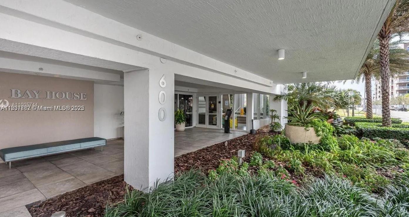 The exterior entrance of a building features a covered walkway, landscaping, and the number 600 — 600 NE 27th St # 105, Miami FL 33137, MIAMI, FL
