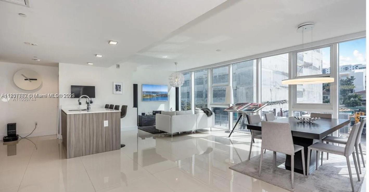 A modern open-concept living and dining area with white tile floors and floor-to-ceiling windows — 600 NE 27th St # 105, Miami FL 33137, MIAMI, FL