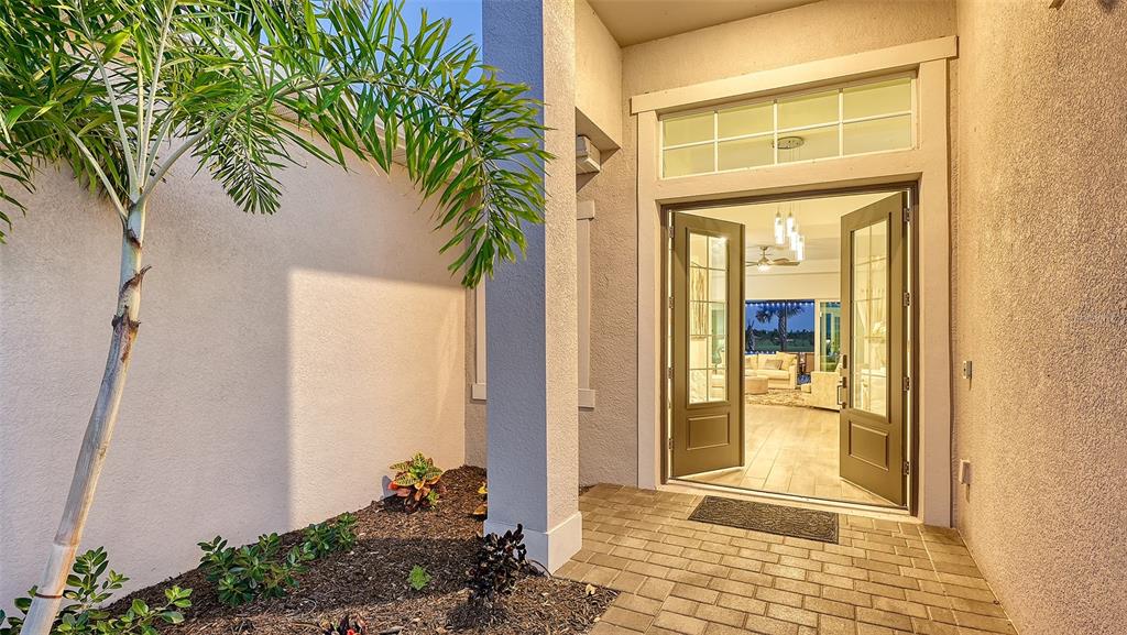 A paved entryway leads to an open double-door entrance with a view into the home — 12453 WELLEN GOLF STREET, VENICE, FL