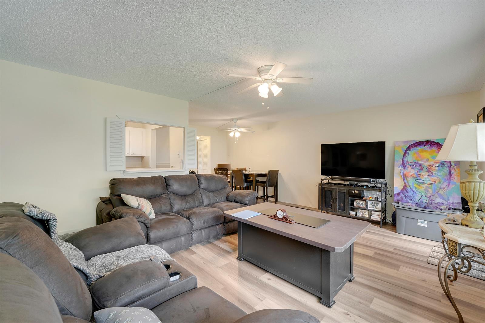 A living room features a grey sectional sofa, a coffee table, and a television stand — 146 Mansfield D, Boca Raton FL 33434, BOCA RATON, FL