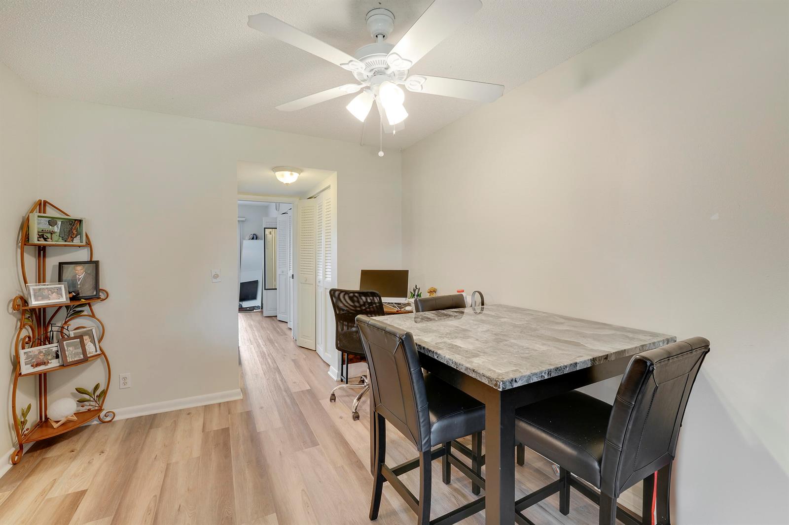 A dining area features a marble-topped table, black chairs, and a decorative metal shelf — 146 Mansfield D, Boca Raton FL 33434, BOCA RATON, FL