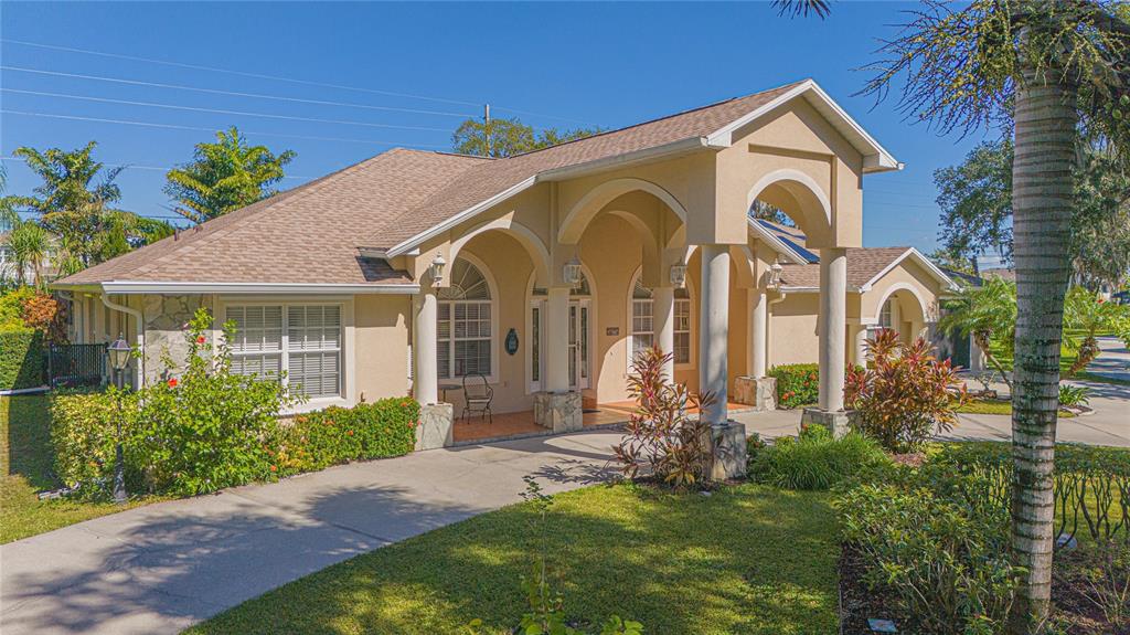 A single-story house with a beige stucco exterior, arched entryway, and a paved driveway — 4735 CHELSEA COURT, KISSIMMEE, FL