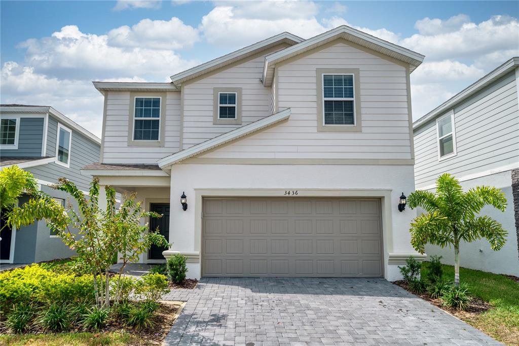 A two-story house with a white stucco and beige siding exterior and a two-car garage — 3436 LILAC WAY, DAVENPORT, FL