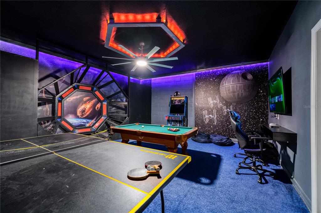 A Star Wars-themed game room features a pool table, ping pong table, and space-themed wall murals — 3436 LILAC WAY, DAVENPORT, FL
