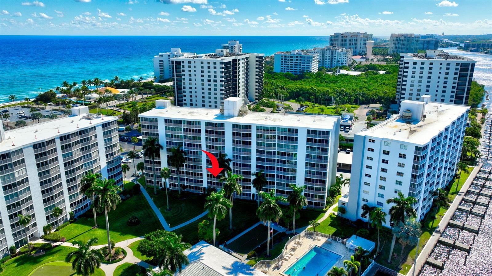 An aerial view of a multi-story residential apartment complex with a pool and palm trees — 3300 S Ocean Boulevard # c, Highland Beach FL 33487, HIGHLAND BEACH, FL