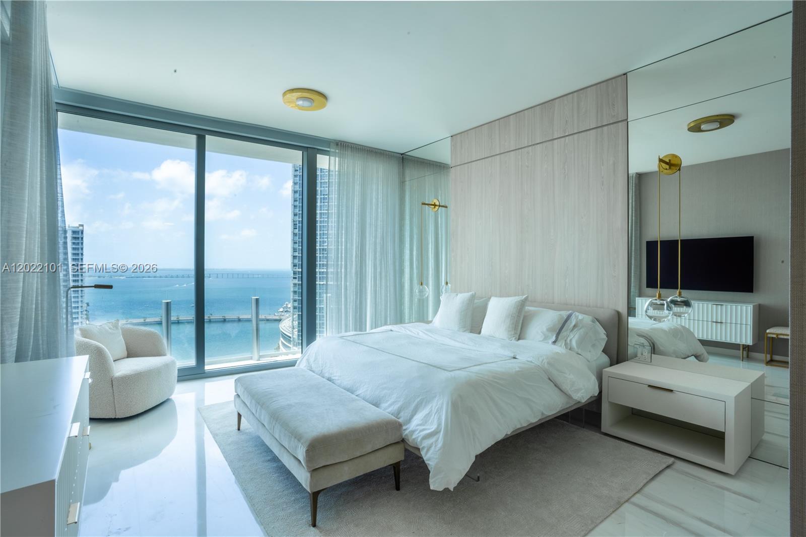 A modern bedroom features a bed, floor-to-ceiling windows, and a panoramic ocean view — 300 Biscayne Boulevard Way # 2203C, Miami FL 33131, MIAMI, FL