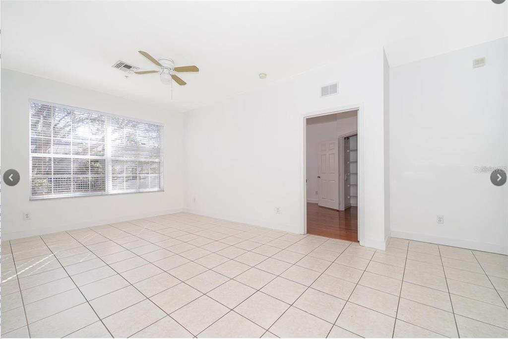 An empty room with white walls, tile flooring, a ceiling fan, and a doorway — 6166 STEVENSON DRIVE UNIT 302, ORLANDO, FL