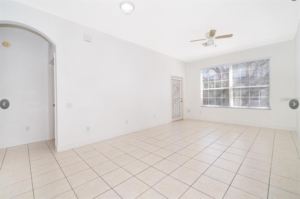 An empty room with white walls, tile flooring, a ceiling fan, and a large window — 6166 STEVENSON DRIVE UNIT 302, ORLANDO, FL