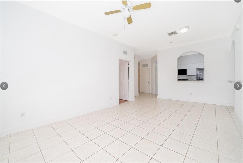 An empty room with white walls, tiled floors, a ceiling fan, and an arched opening — 6166 STEVENSON DRIVE UNIT 302, ORLANDO, FL