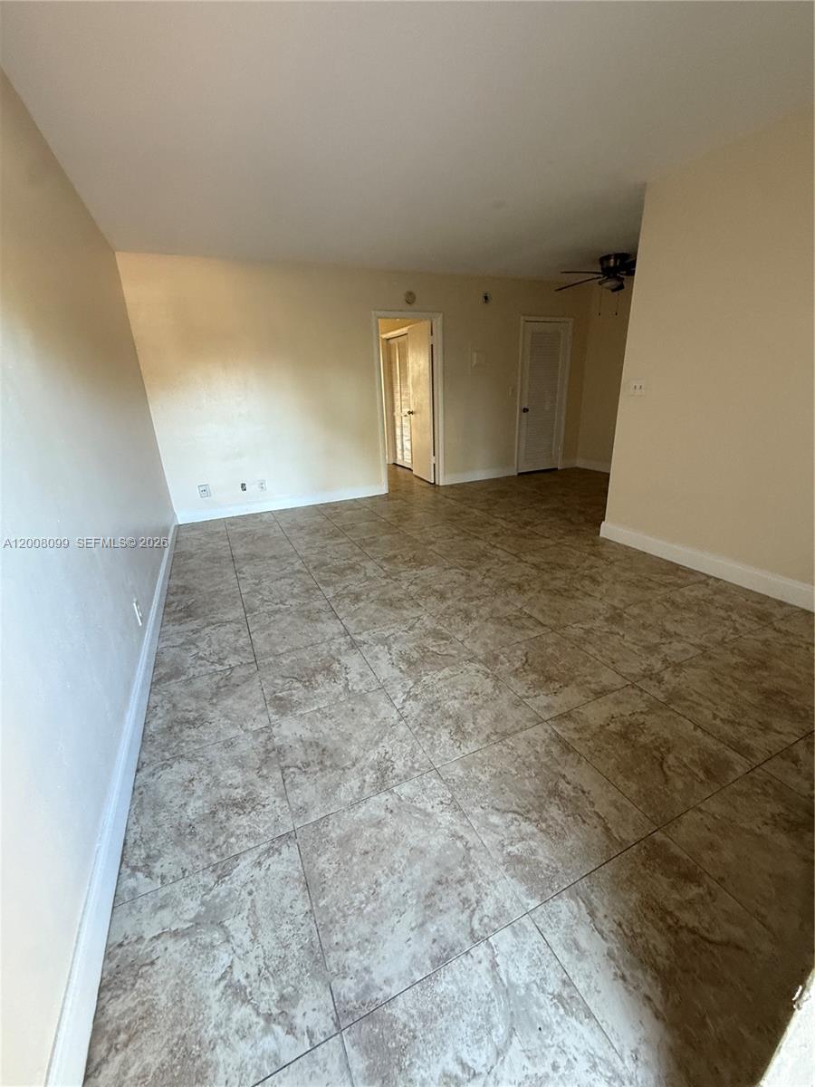An empty room features light-colored walls and large, square, mottled-brown floor tiles — 1211 NE 23rd Ave # 2, Pompano Beach FL 33062, POMPANO BEACH, FL