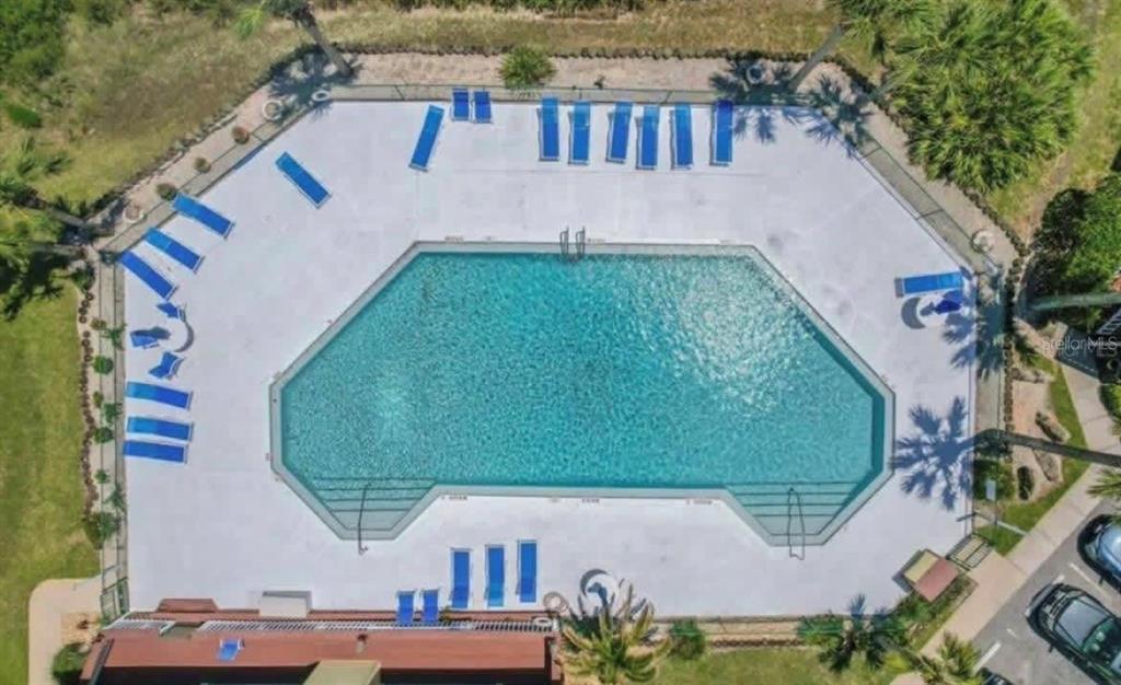 An aerial view of a swimming pool surrounded by a concrete deck and lounge chairs — 1003 OCEAN MARINA DRIVE UNIT 1003, FLAGLER BEACH, FL