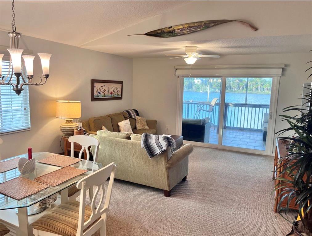A dining area and living room with a sliding glass door overlooking a waterfront balcony — 1003 OCEAN MARINA DRIVE UNIT 1003, FLAGLER BEACH, FL