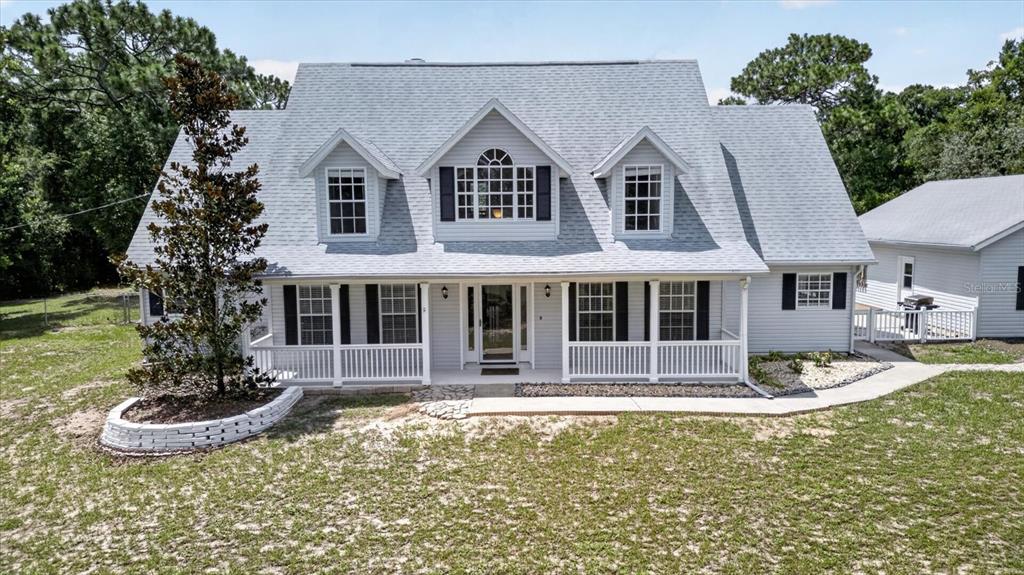A two-story house with a gray roof, white siding, and a front porch — 34244 RIDGE MANOR BOULEVARD, DADE CITY, FL
