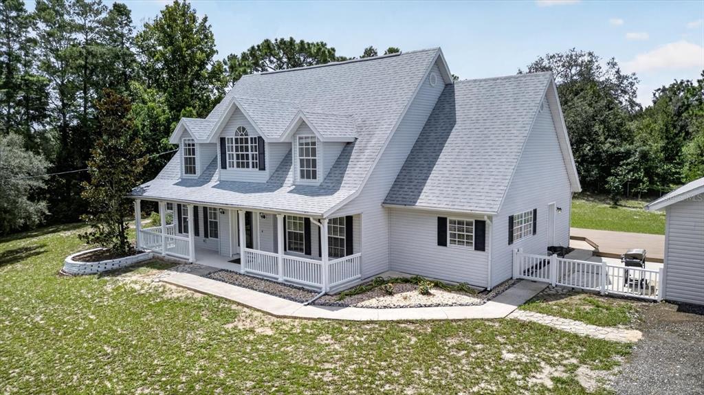 A two-story house with light gray siding, a front porch, and three dormer windows — 34244 RIDGE MANOR BOULEVARD, DADE CITY, FL