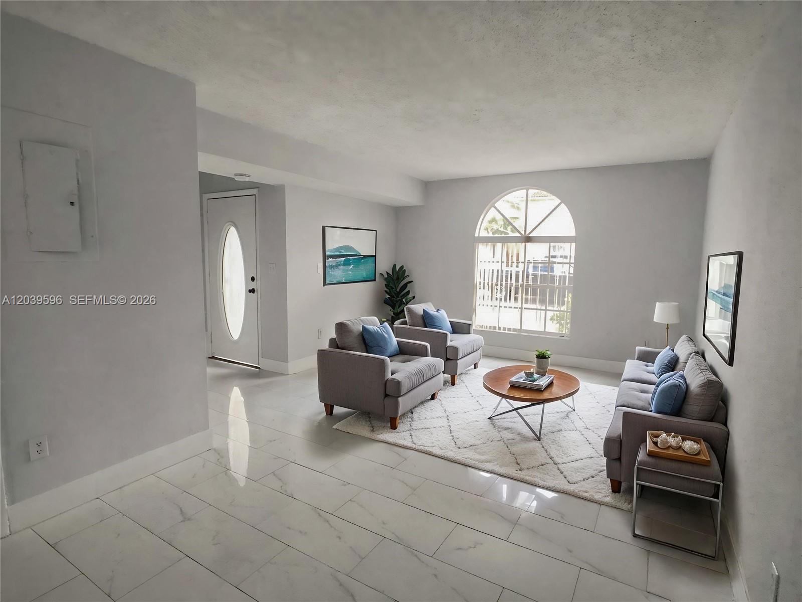 A living room features gray furniture, a round coffee table, and white tile flooring — 7211 W 24th Ave # 2263, Hialeah FL 33016, HIALEAH, FL