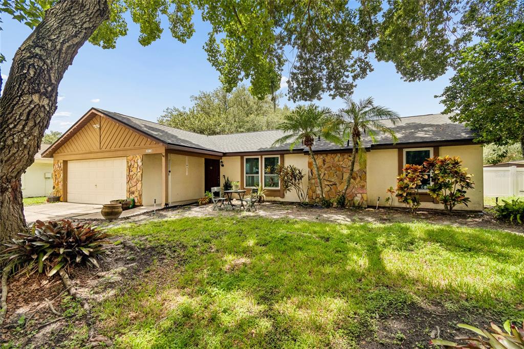 A single-story house with a stone facade, a two-car garage, and a front yard — 15116 TRAIL CREEK PLACE, TAMPA, FL