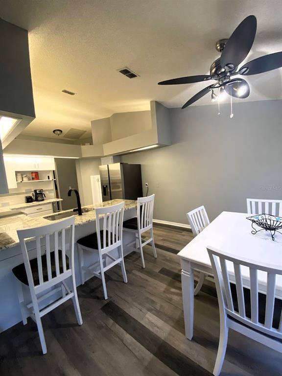 A kitchen with a breakfast bar and a dining area featuring wood-look flooring — 111 LINDALE STREET, LAKELAND, FL