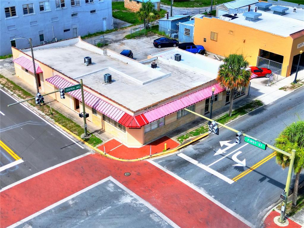 An aerial view of a corner commercial building with a pink awning at an intersection — 1 W CENTRAL AVENUE, LAKE WALES, FL