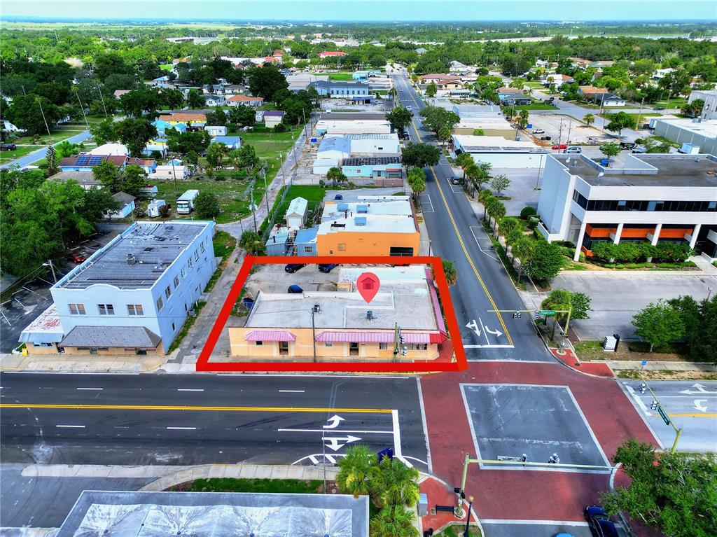An aerial view shows a single-story commercial building outlined in red at a street intersection — 1 W CENTRAL AVENUE, LAKE WALES, FL