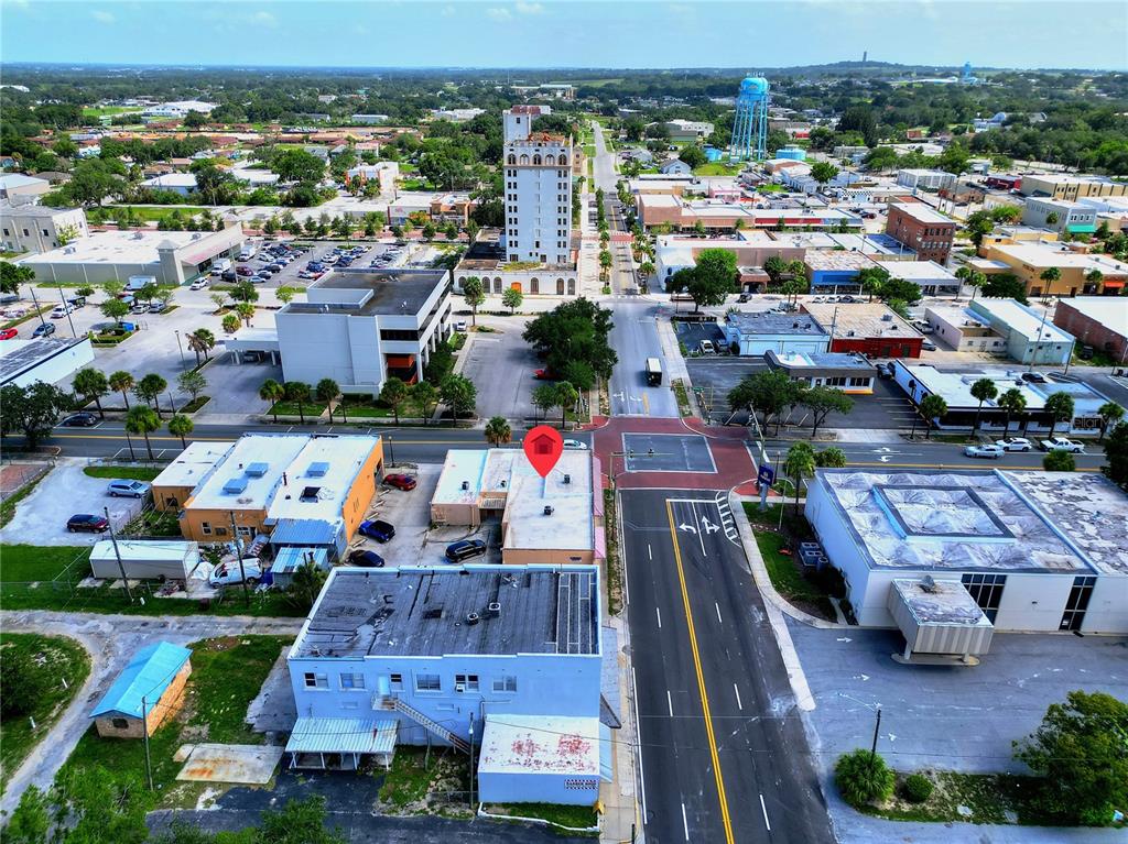 An aerial view shows a commercial building with a red location pin in a town — 1 W CENTRAL AVENUE, LAKE WALES, FL