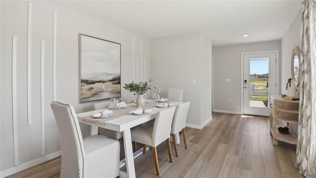A dining room features a white table, upholstered chairs, wall molding, and a glass door — 2130 NE 33RD LANE, OCALA, FL