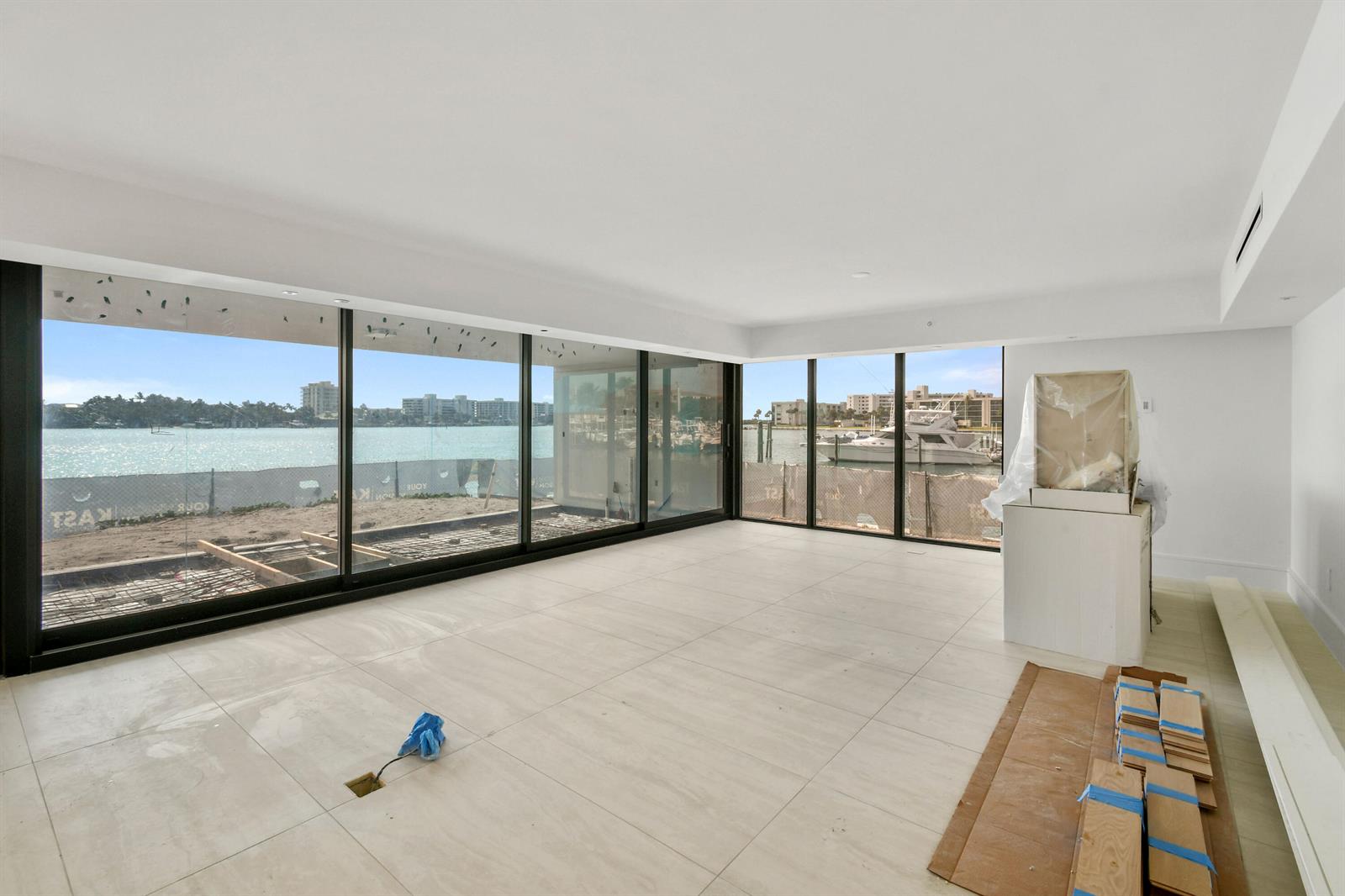 An unfinished room with large glass sliding doors overlooking a waterfront construction site — 12450 SE Crystal Cove Place # 13, Jupiter FL 33469, JUPITER, FL