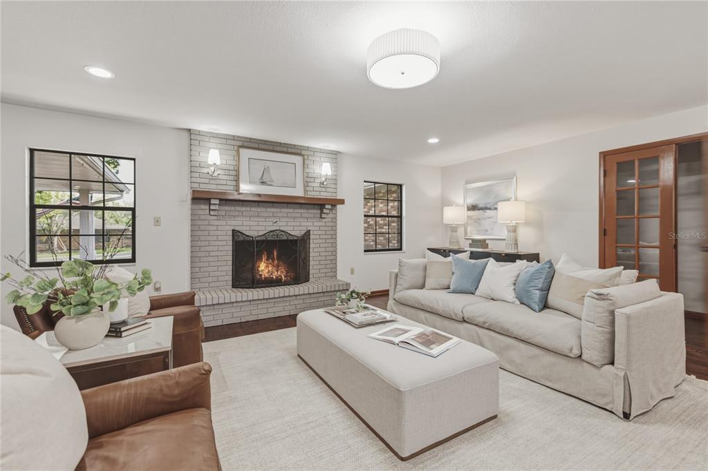 A living room features a white brick fireplace, a large sofa, and two leather chairs — 236 PINELLAS STREET, LAKELAND, FL