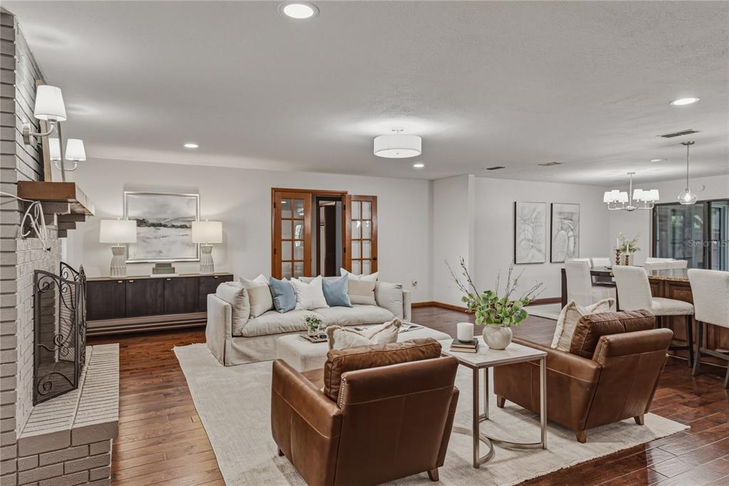 A living room features a brick fireplace, leather armchairs, a sofa, and hardwood flooring — 236 PINELLAS STREET, LAKELAND, FL