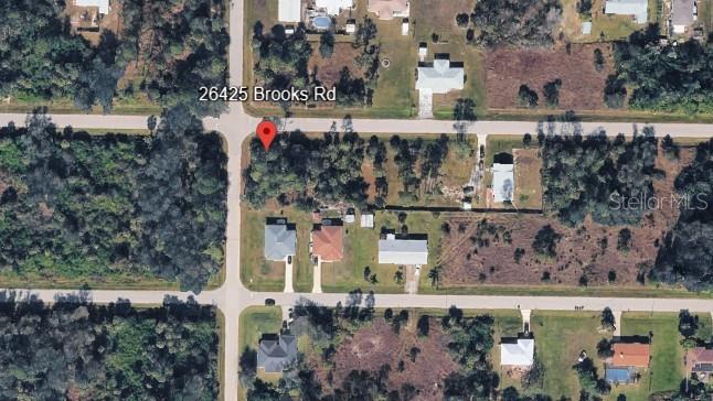 This aerial map shows a vacant, wooded residential lot located at a street intersection — 26425 BROOKS ROAD, PUNTA GORDA, FL