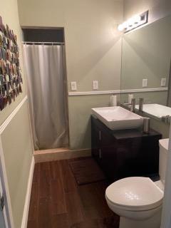 A bathroom features a dark vanity with a vessel sink, a shower, and wood flooring — 20020 NE 6th Court, Miami FL 33179, MIAMI, FL