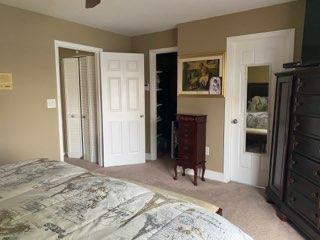 A bedroom features tan walls, a patterned bedspread, a dark wood dresser, and multiple doors — 20020 NE 6th Court, Miami FL 33179, MIAMI, FL