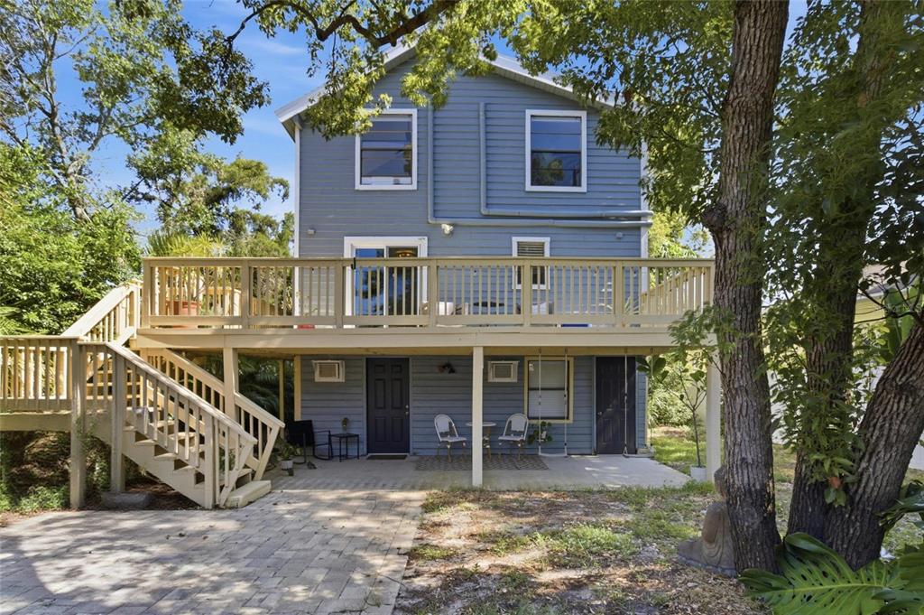 A three-story blue house with two stacked wooden balconies and an exterior staircase — 304 16TH AVENUE N, ST PETERSBURG, FL