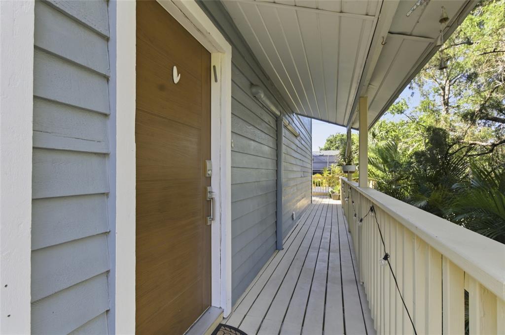 A two-story blue house features a large wooden deck and a ground-level patio area — 304 16TH AVENUE N, ST PETERSBURG, FL