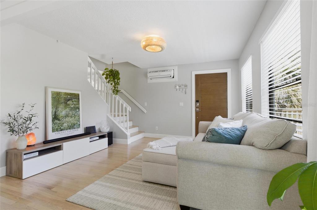 A living and dining area features a stone fireplace, light wood floors, and a sofa — 304 16TH AVENUE N, ST PETERSBURG, FL
