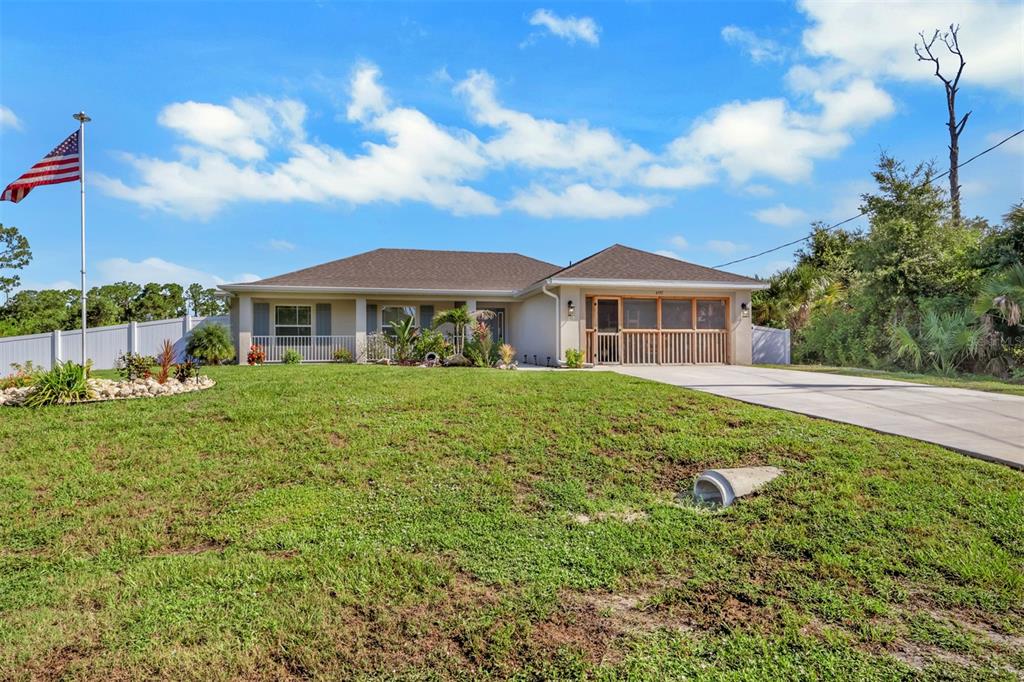 A single-story house with a screened porch, a concrete driveway, and an American flag — 4597 KENVIL DRIVE, NORTH PORT, FL