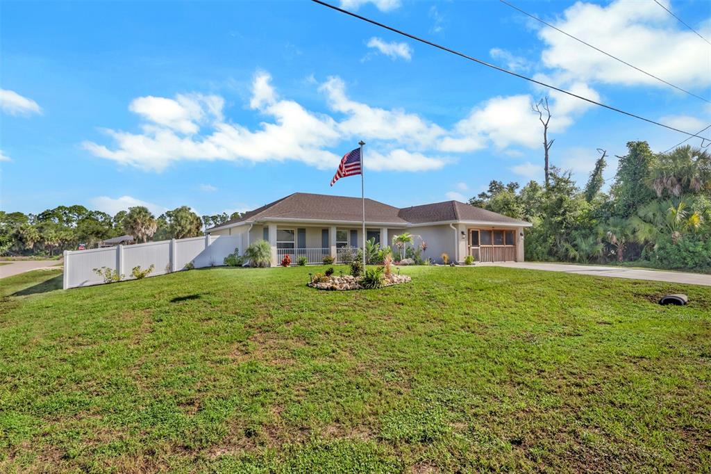 A single-story house with a brown roof, a flag pole, and a white privacy fence — 4597 KENVIL DRIVE, NORTH PORT, FL