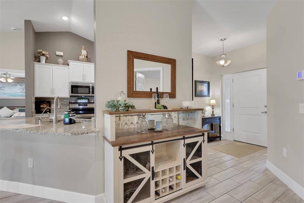A bar cabinet with a mirror sits in an entryway next to a kitchen counter — 4597 KENVIL DRIVE, NORTH PORT, FL