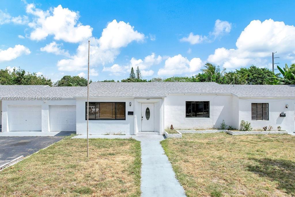 A single-story white house with a front lawn, a walkway, and a garage — 2417 Pierce St, Hollywood FL 33020, HOLLYWOOD, FL