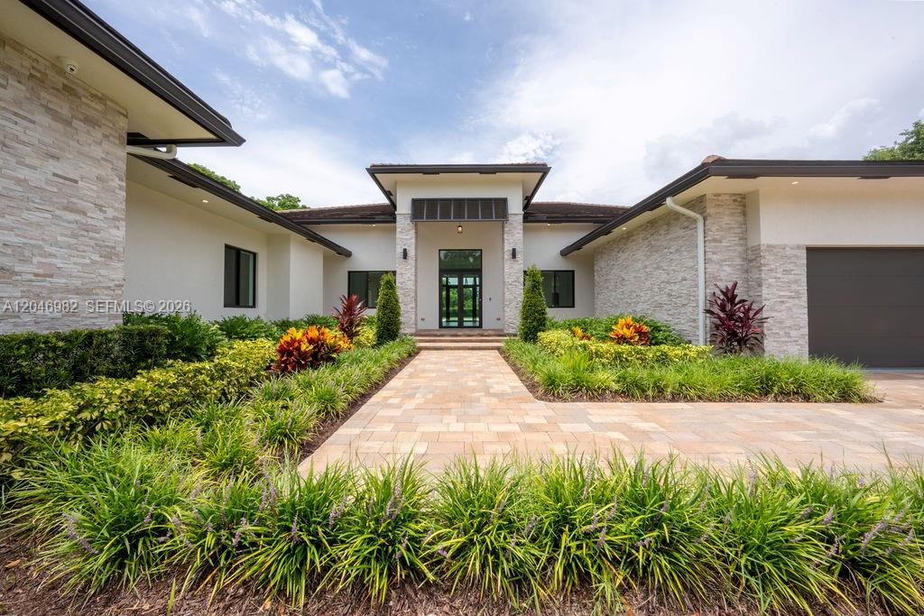 A modern single-story house features a stone facade, a paved walkway, and manicured landscaping — 11861 NW 9th St, Plantation FL 33325, PLANTATION, FL