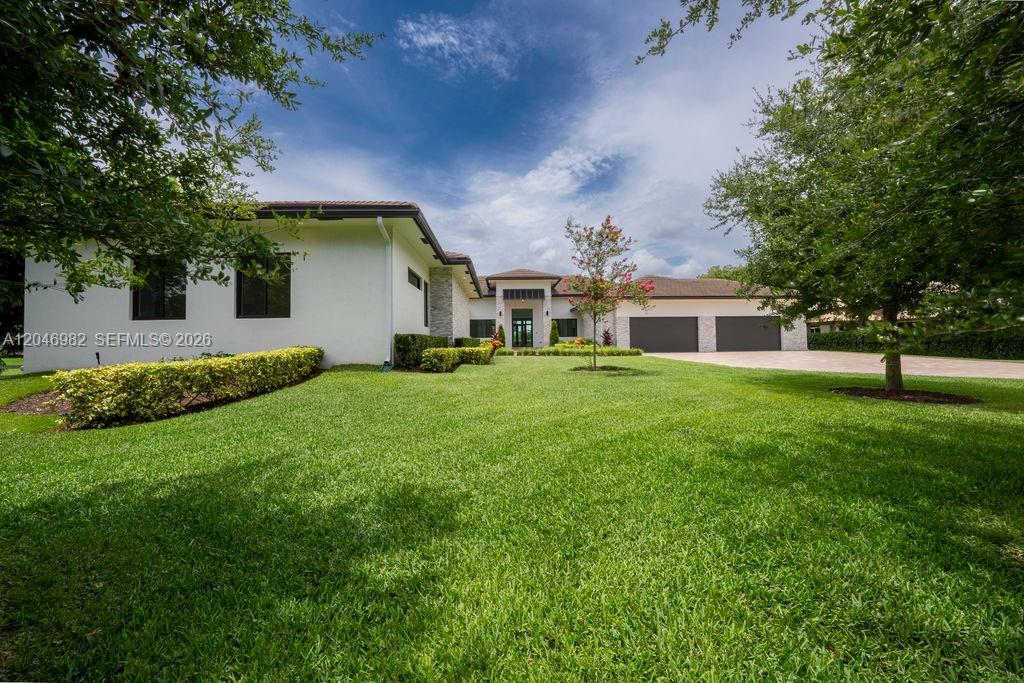 A single-story house with a white exterior, a three-car garage, and a large front lawn — 11861 NW 9th St, Plantation FL 33325, PLANTATION, FL