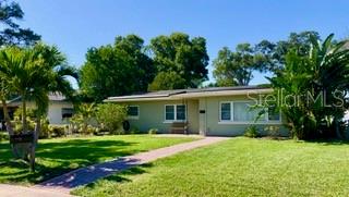 A single-story house with a light green exterior, a flat roof, and a front lawn — 604 7TH AVENUE SW, LARGO, FL