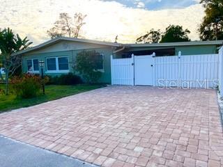 A single-story house with a paved driveway and a white vinyl privacy fence — 604 7TH AVENUE SW, LARGO, FL