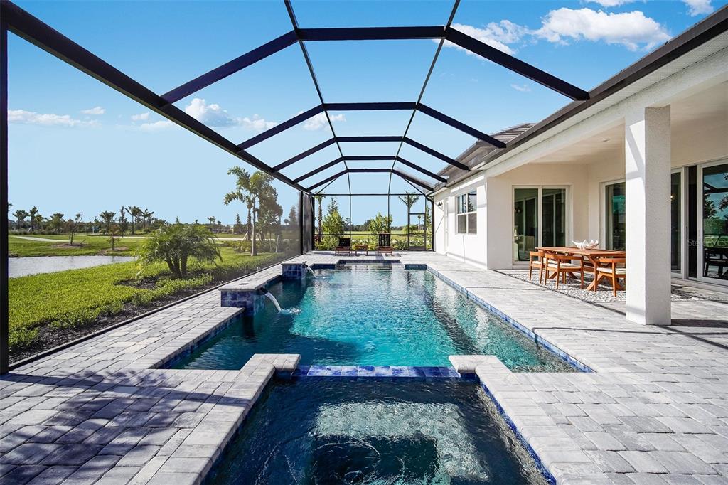 A screened-in patio features a swimming pool, a hot tub, and a dining area — 18939 CHERRYSTONE WAY, LAKEWOOD RANCH, FL